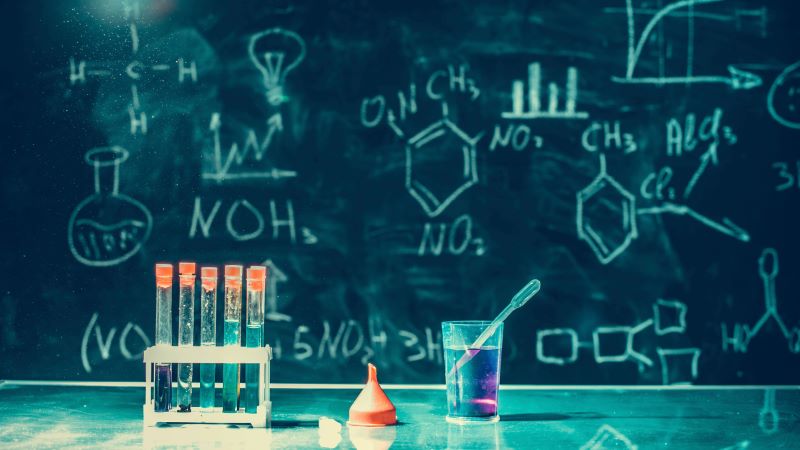 Chemistry on blackboard and lab tubes.