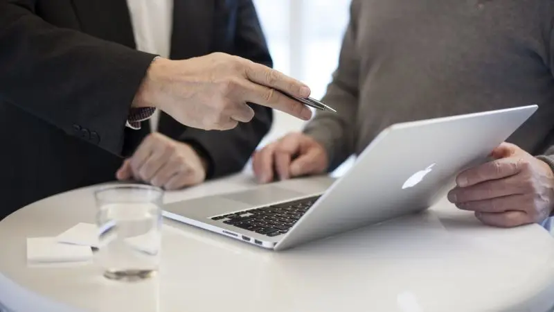 Colleagues having discussion in front of the laptop.