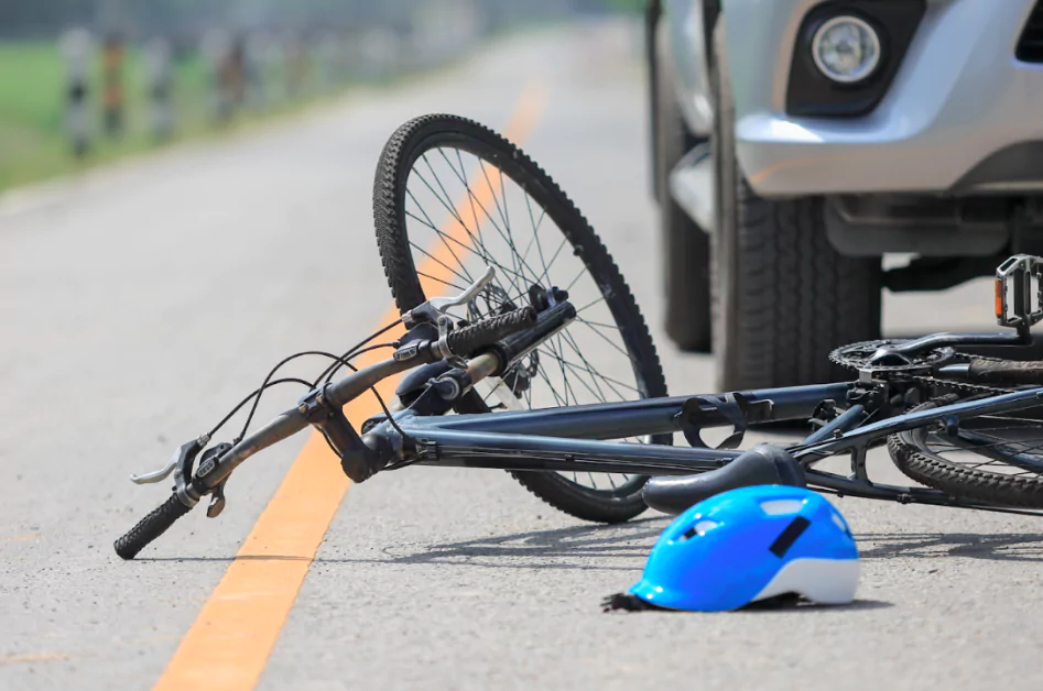 Tripped bicycle and blue helmet in the middle of the road after a crash.