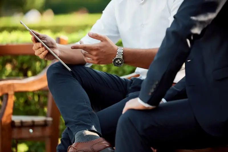 Professional men pointing to a tablet.